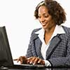 African-American woman sitting at a desk working on laptop